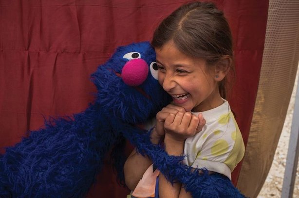 Grover the Sesame Street muppet meets a refugee child in Jordan