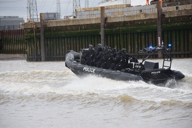 Armed police race to the scene in an anti-terror exercise held on the Thames on Sunday