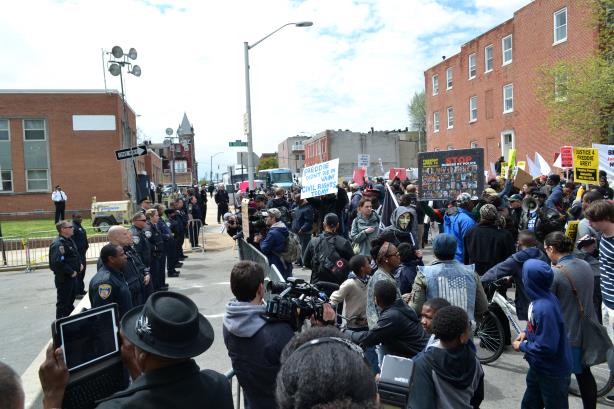 A protest at a Baltimore Police Department building. (Image via Wikimedia Commons). 