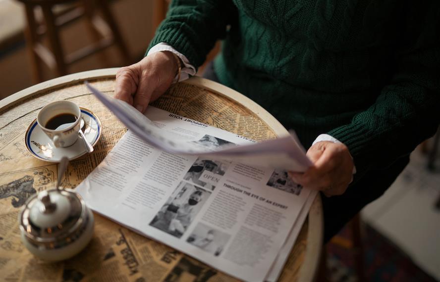 Stock image of a woman reading a newspaper.