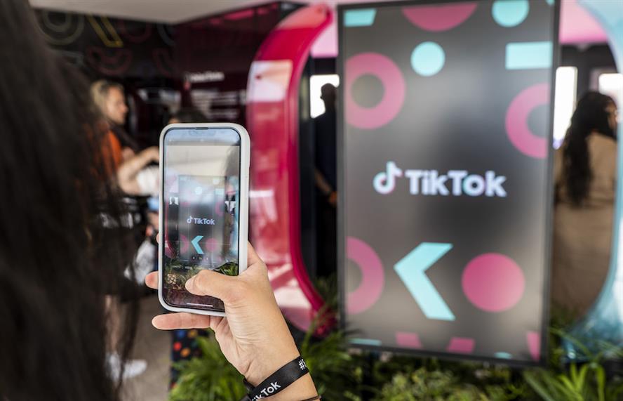 A woman takes a photo of a TikTok billboard on her mobile phone. All photos: Olivier Anrigo