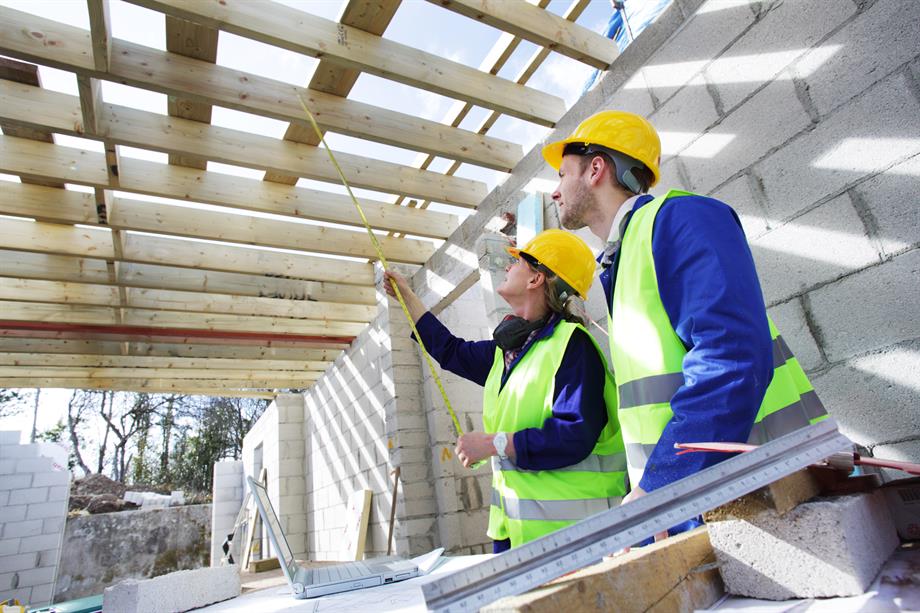 Builders taking measurement in unfinished building - stock photo