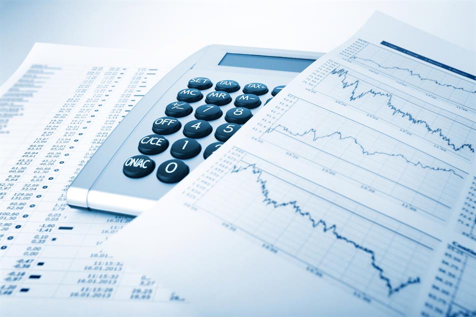 A couple of paper spreadsheets denotoing financial info and a calculator