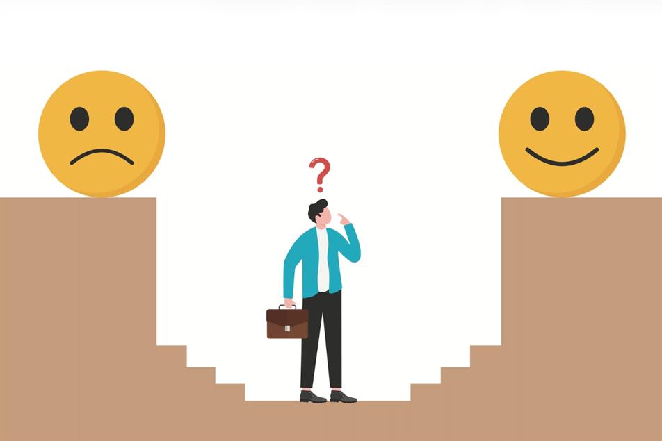 A man stands in the middle of a happy face and a sad face.